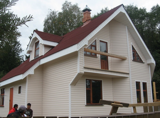 После утепления деревянный дом можно обшить сайдингом.