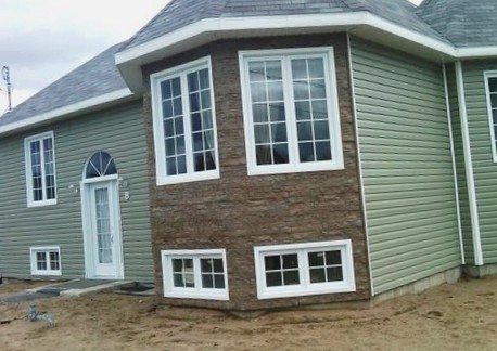 Пеноблочный дом с комбинированной отделкой виниловым и цокольным сайдингом.
